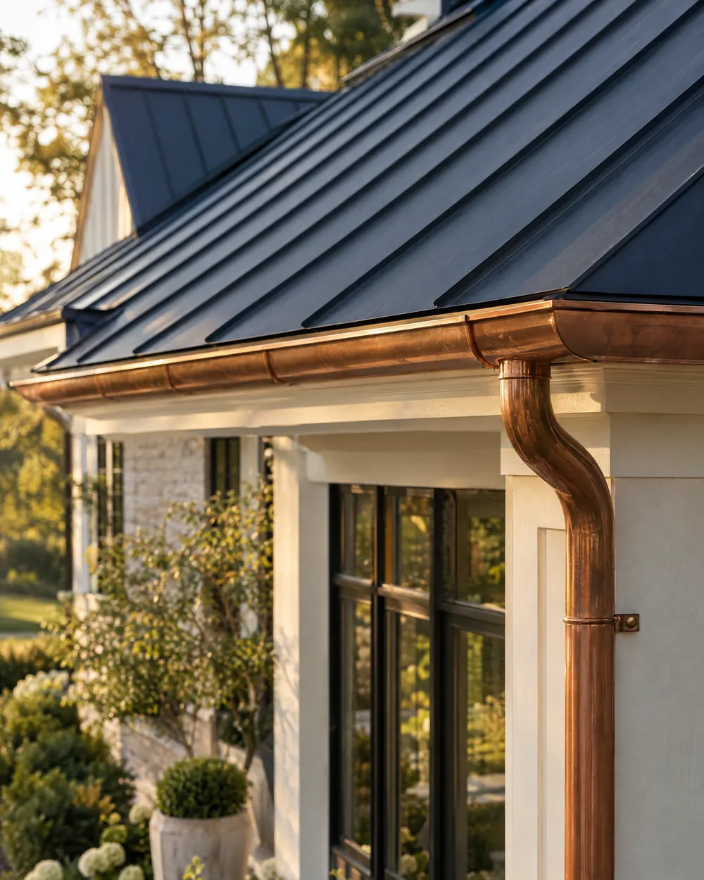 Standing-seam metal roof panels above a copper gutter and downspout
